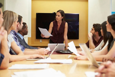 A woman giving a presentation to a group of people in a modern conference room - Future of Work- Inter-American Development Bank - IDB